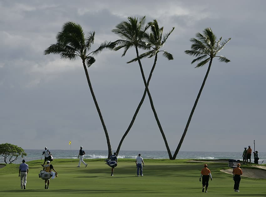 Matt Kuchar, Webb Simpson and Luke Donald's group approaches the 16th green during the second round of the Sony Open golf tournament, in Honolulu. 