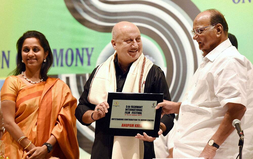 Veteran actor Anupam Kher receives Lifetime Achievement Award from NCP leader Sharad Pawar and Supriya Sule during Yashwant International Film Festival in Mumbai.