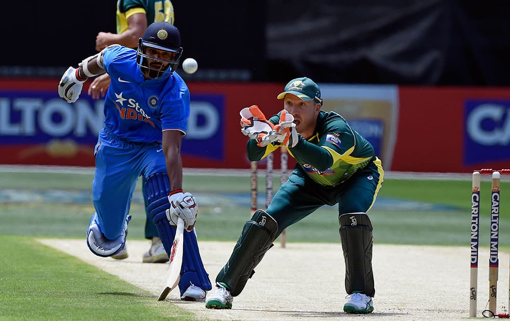 India's Shikhar Dhawan avoids a run out as Australia's Brad Haddin, right, fields the ball during their one-day international cricket match in Melbourne.