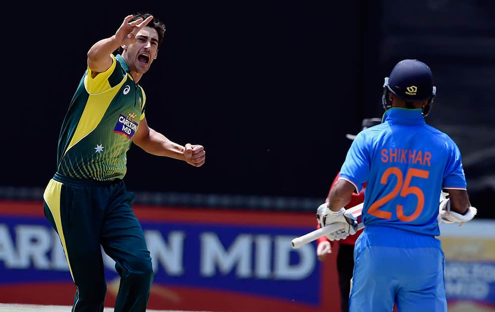 Australia's Mitchell Starc, celebrates the wicket of India's Shikhar Dhawan, right, during their one-day international cricket match in Melbourne.