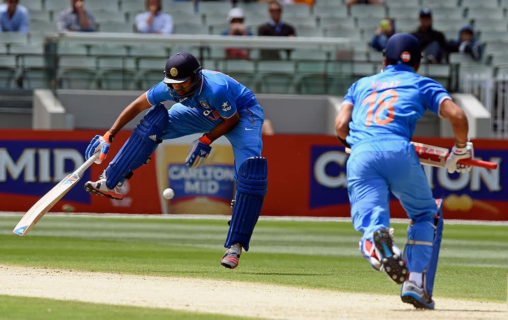 India's Rohit Sharma jumps over the ball hit from team mate Virat Kohli, right, during their One Day International cricket match against Australia in Melbourne.