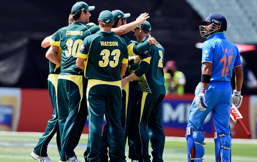 Australian players celebrate the wicket of India's Virat Kohli during their one-day international cricket match in Melbourne,.