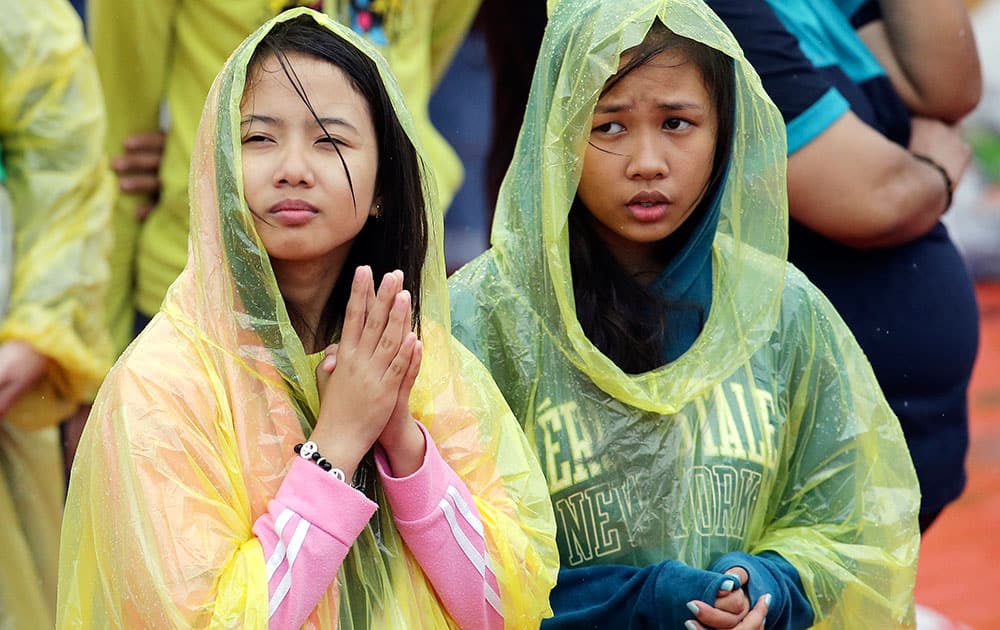 Young Filipino women pray during the visit of Pope Francis to meet the youth at the University of Santo Tomas in Manila, Philippines.