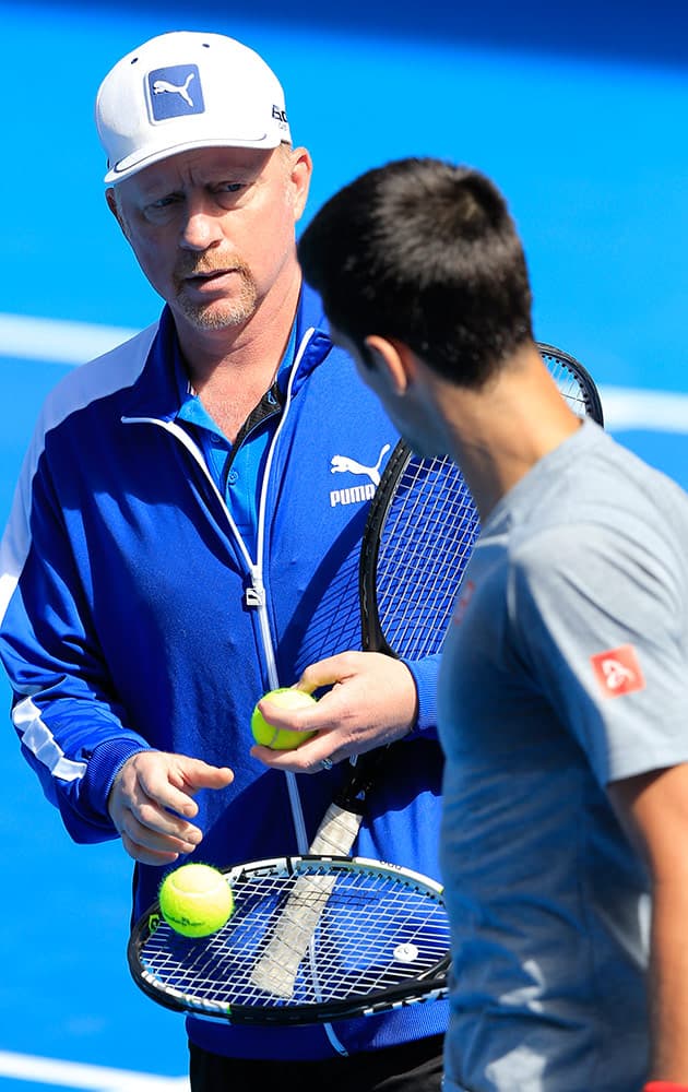 Boris Becker, coach of Novak Djokovic of Serbia, talks with Djokovic during a training session at the Australian Open tennis championship in Melbourne, Australia, Sunday.