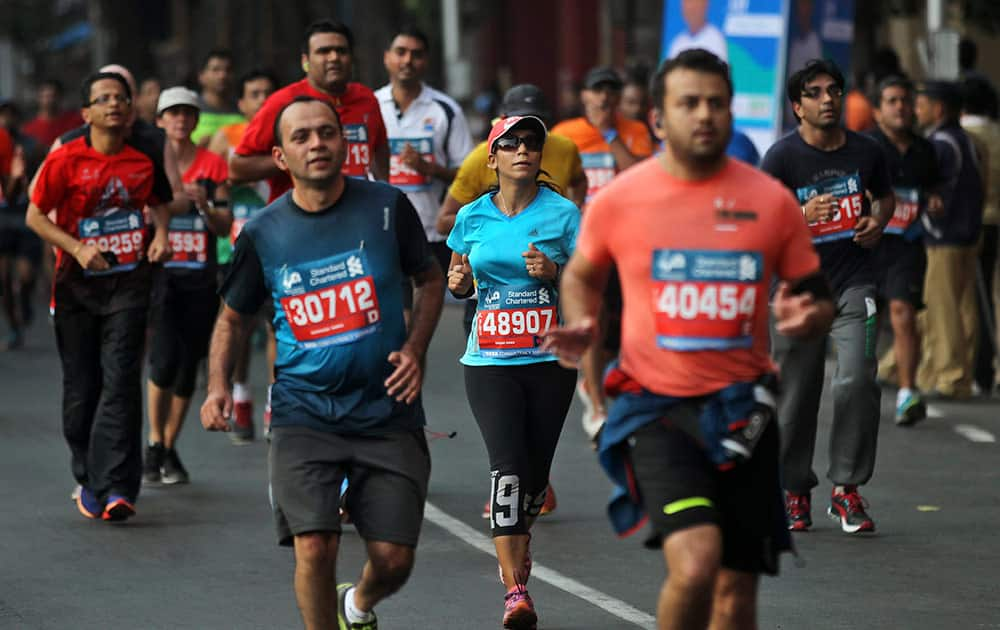 Competitors run during the Mumbai Marathon in Mumbai, India, Sunday. Thousands of city residents alongside athletes took part in the event.