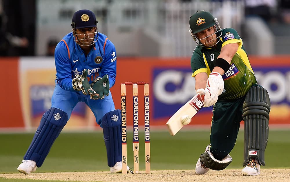 India's MS Dhoni, watches on as Australia's Shane Watson, hits four runs during their One Day International cricket match in Melbourne, Sunday.