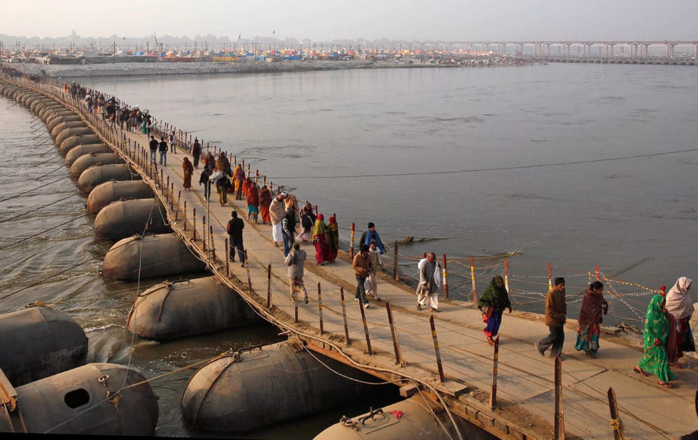 Hindu devotees cross a temporary pontoon bridge at Sangam, the confluence of the Rivers Ganges, Yamuna and mythical Saraswati during the annual traditional fair of “Magh Mela” in Allahabad, India, Sunday.