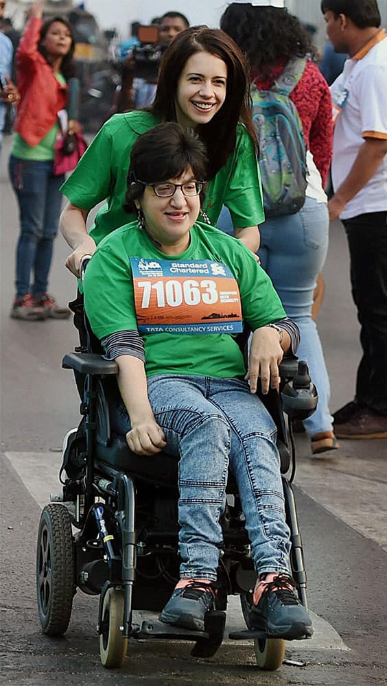 actress Kalki Koechlin runs with a handicap girl during the Standard Chartered marathon.