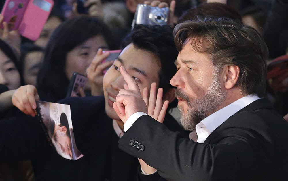 Actor and director Russell Crowe poses for pictures with fans during the red carpet event for his new movie 
