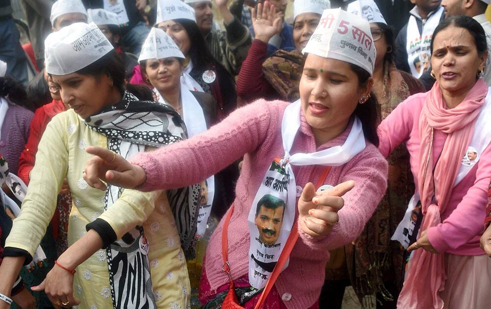 Supporters of AAP leader Manish Sisodia dance during his nomination filing procession for upcoming Assembly elections at Geeta Colony SDM office in New Delhi.