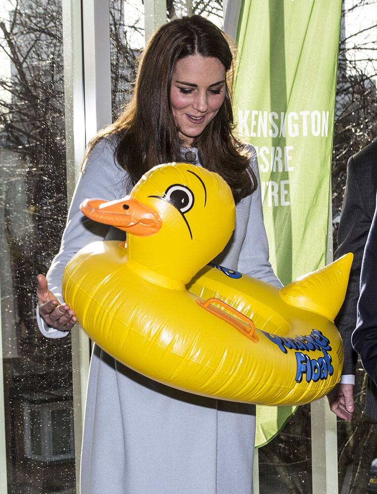 Britain's Kate, Duchess of Cambridge is presented with a large inflatable duck swim float for her son Prince George during her tour of the new Kensington leisure centre. 