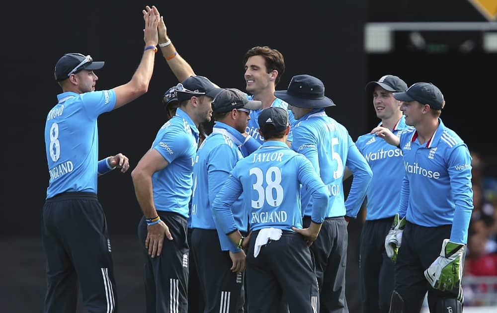 England's Steven Finn, celebrates with his teammates after he got the wicket of India's MS Dhoni during the one day International cricket match between England and India in Brisbane, Australia.