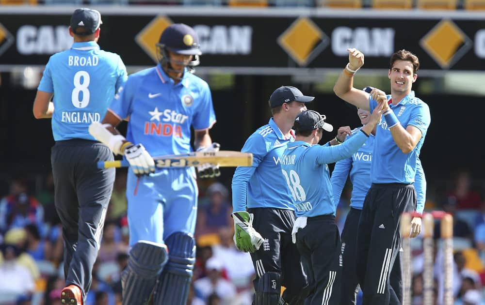 England's Steven Finn, celebrates with his teammates after he got the wicket of India's Axar Patel, during the one day International cricket match between England and India in Brisbane, Australia.