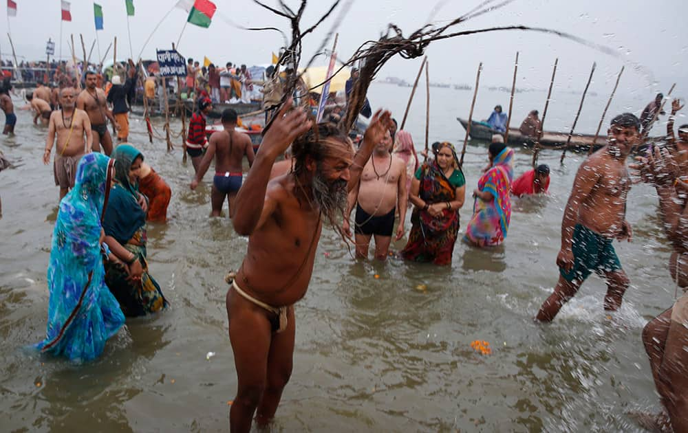 A Hindu holy man takes a holy dip at the Sangam, the confluence of the Ganges and Yamuna rivers, on 