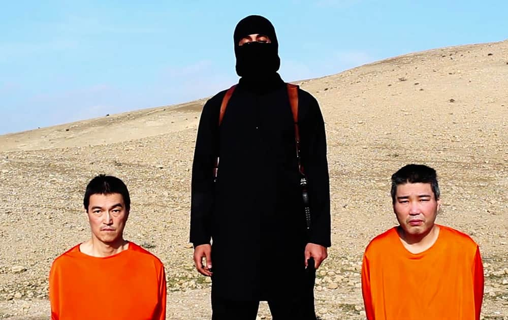 This image taken from an online video released by the Islamic State group's al-Furqan media arm on Tuesday, Jan. 20, 2015, purports to show the group threatening to kill two Japanese hostages that the militants identify as Kenji Goto Jogo, left, and Haruna Yukawa, right, unless a $200 million ransom is paid within 72 hours.