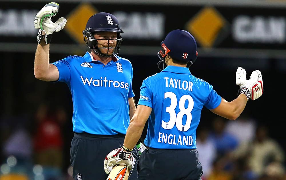 England's Ian Bell, and James Taylor, celebrate after England won the one day International cricket match against India in Brisbane, Australia.