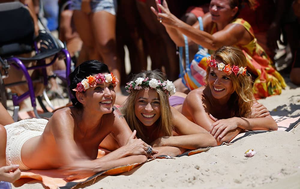 Film producer Ana Paula, left, disability rights advocate Natache, center, and contemporary dancer Karla Klemente join a demonstration on Ipanema beach in support of the rights of women to go topless on beaches nationwide, in Rio de Janeiro, Brazil.