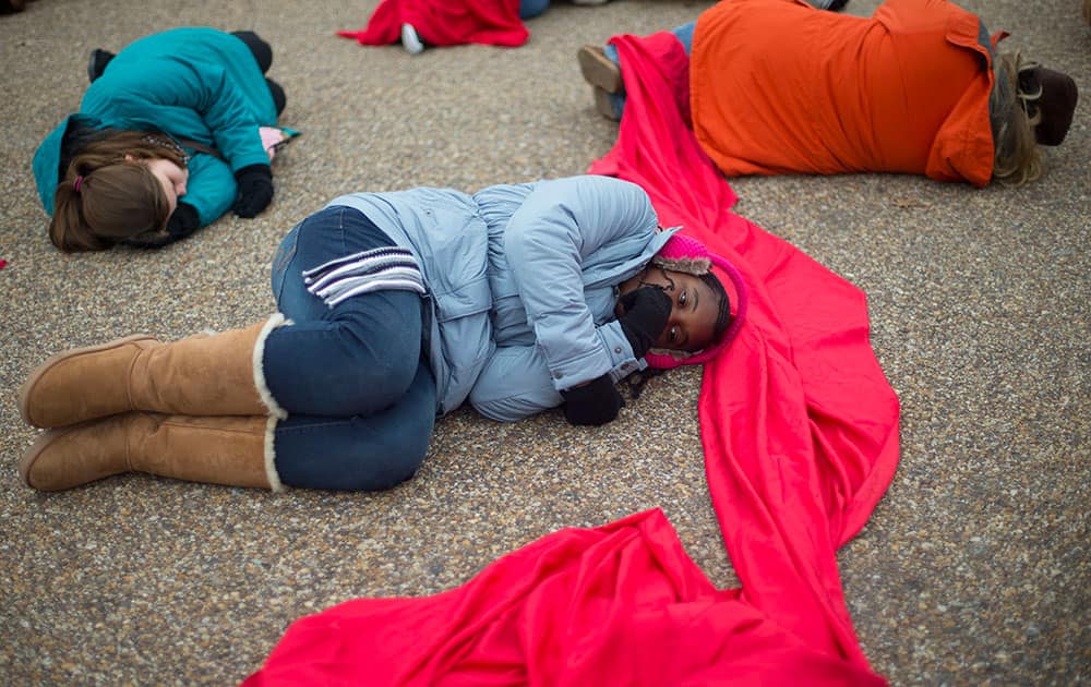 Anti-abortion rights activists are connected with a red piece of cloth as they stage a 'die-in' in front of the White House in Washington.