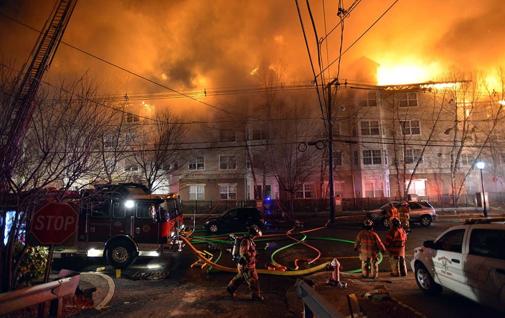 Firefighters work at a multialarm fire at an apartment building, in Edgewater, N.J. The cause of the fire is not yet known. Witnesses say it was producing massive flames and large plumes of thick, black smoke that were visible across the Hudson River in New York City.