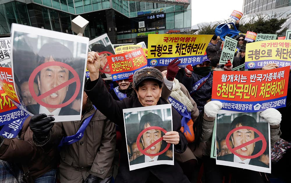 Members of conservative groups hold defaced portraits of former Unified Progressive Party lawmaker Lee Seok-ki as they shout slogans during a rally denouncing Lee near the Supreme Court in Seoul, South Korea.