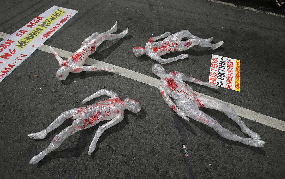 Human figures made of plastic lay on the ground as part of an exhibit by activists to commemorate the 1987 killing of demonstrators during a rally in Manila, Philippines.