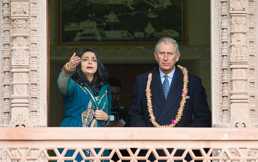 Britain's Prince Charles The Prince of Wales, looks out at the gardens of the Jain Temple in Potters Bar, England, with Arshana Sanghrajka, an expert in Jain Temple Architecture.