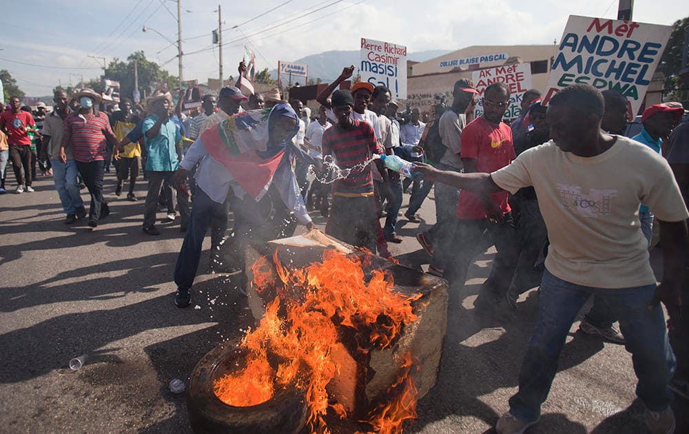 Demonstrators set tires on fire during a protest to demand the resignation of President Michel Martelly in Port-au-Prince, Haiti.
