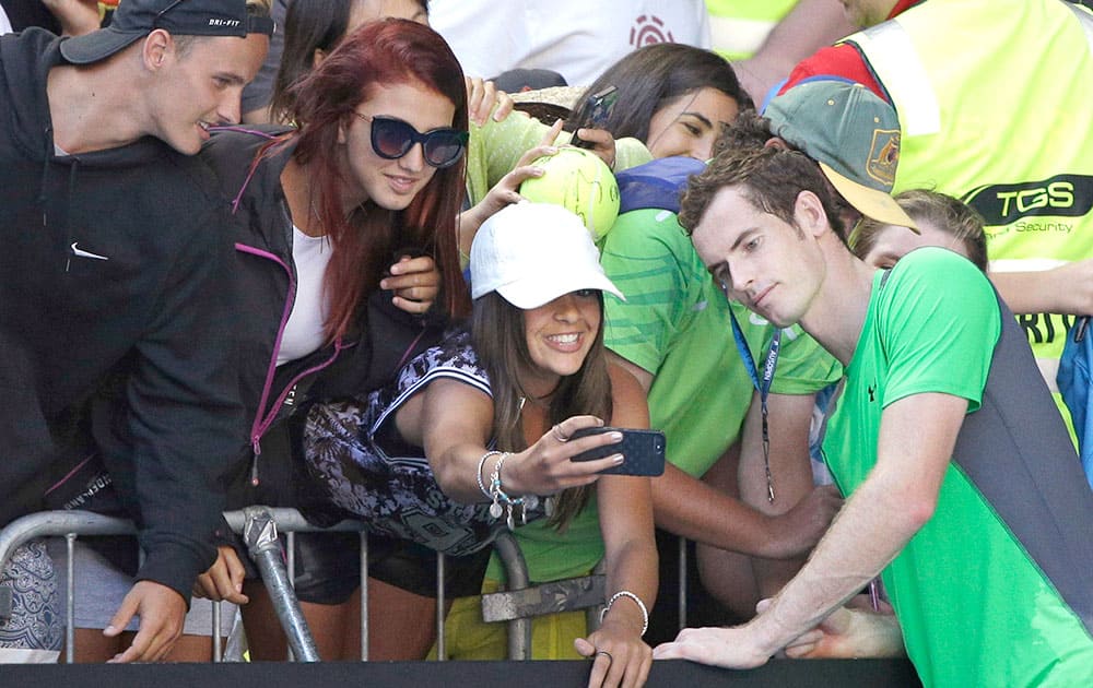 Andy Murray of Britain, poses for a fan's photo, after defeating Joao Sousa of Portugal during their third round match at the Australian Open tennis championship in Melbourne, Australia.