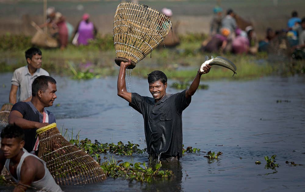 A tribal Tiwa man displays his catch during a community fishing event as part of the Jonbeel festival near Jagiroad.