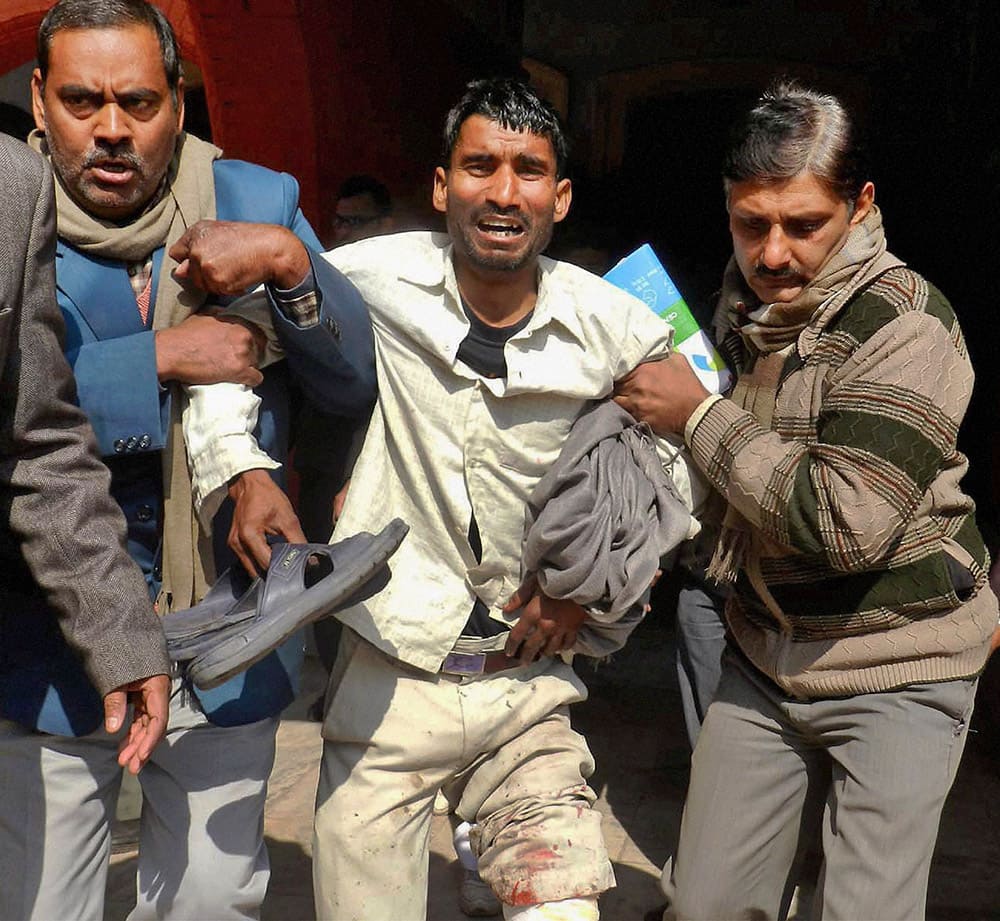 People help an injured victim after an explosion in Arrah, a town 65 kilometers (40 miles) southwest of Patna, the capital of Bihar. A crude bomb exploded Friday in a courthouse in eastern India, killing two people and injuring more than 10 others, police said. 