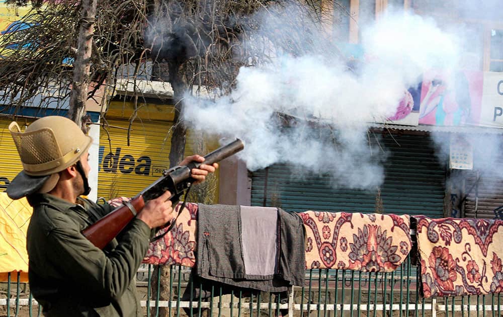 A policeman fires teargas shells to disperse protesters during a clash following a protest against the publication of the blasphemous sketches of the Prophet Muhammad(SAW) in a French magazine, at Nowhatta in Srinagar.