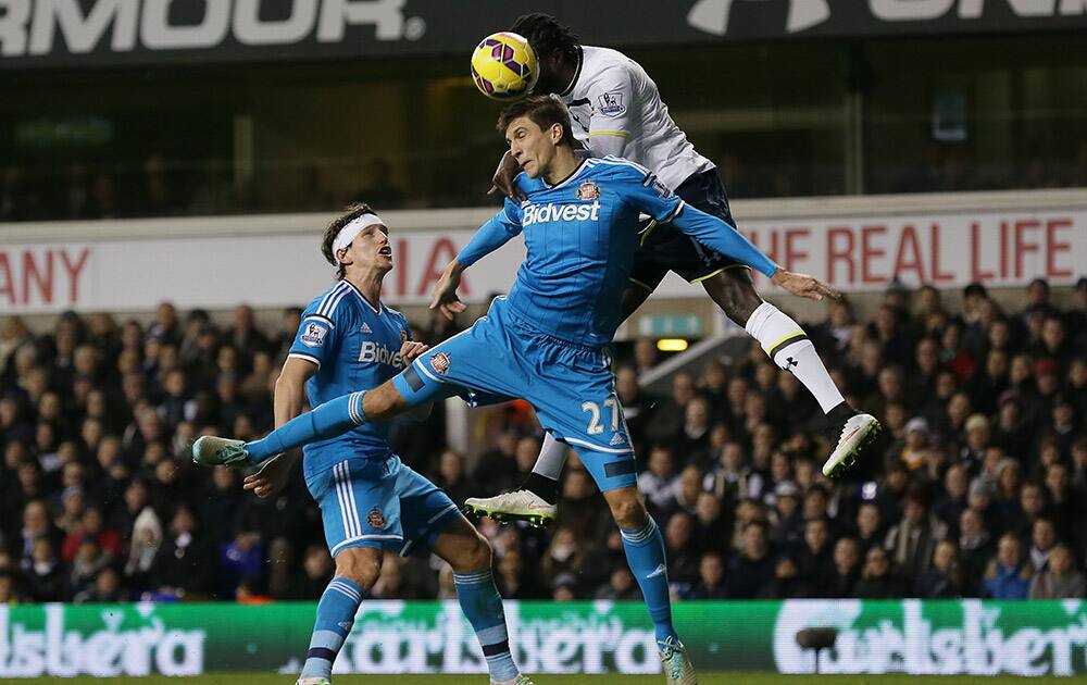 Tottenham Hotspur's Emmanuel Adebayor, right, competes for the ball with Sunderland's Santiago Vergini during the English Premier League soccer match between Tottenham Hotspur and Sunderland at White Heart Lane, London, England.