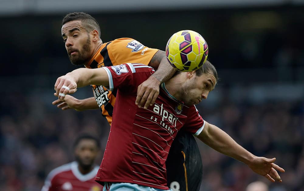 West Ham's Andy Carroll, right, competes for the ball with Hull City's Tom Huddlestone during the English Premier League soccer match between West Ham and Hull City at Upton Park stadium in London.