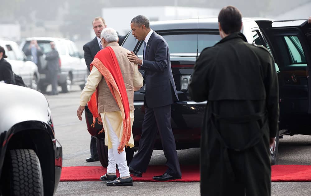 President Barack Obama walks with Indian Prime Minister Narendra Modi as he arrives on Air Force One at Air Force Station Palam, in Palam, India.