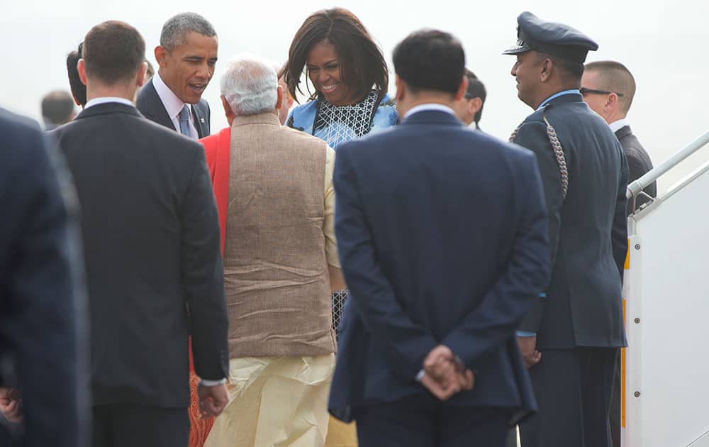 President Barack Obama and first lady Michelle Obama are greeted by Indian Prime Minister Narendra Modi as they arrive at Air Force Station Palam, in Palam, India.