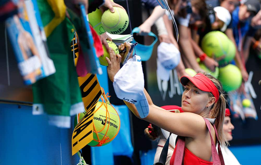 Maria Sharapova of Russia signs autographs for fans after defeating Peng Shuai of China in their fourth round match at the Australian Open tennis championship in Melbourne, Australia.