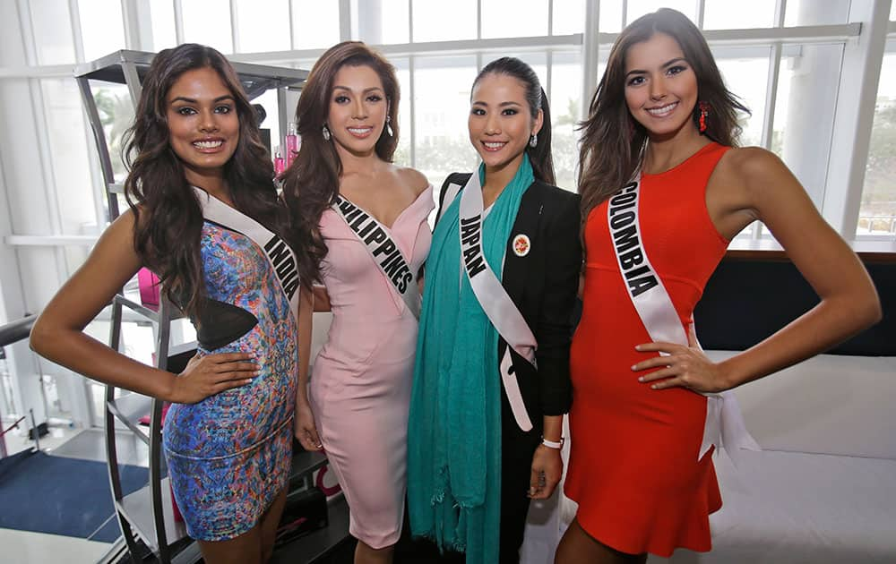 Miss Universe contestants Noyonita Lodh, left, of India, Mary Jean Lastimosa, second from left, of the Philippines, Keiko Tsuji, second from right, of Japan, and Paulina Vega of Colombia pose for photos during a break in rehearsals.