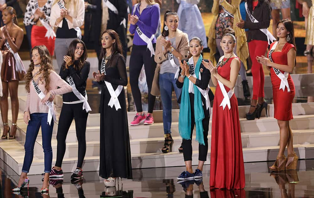 Miss Universe contestants clap as they rehearse, Saturday, Jan. 24, 2015, at Florida International University in Miami. The Miss Universe pageant will be held Jan. 25, in Miami.