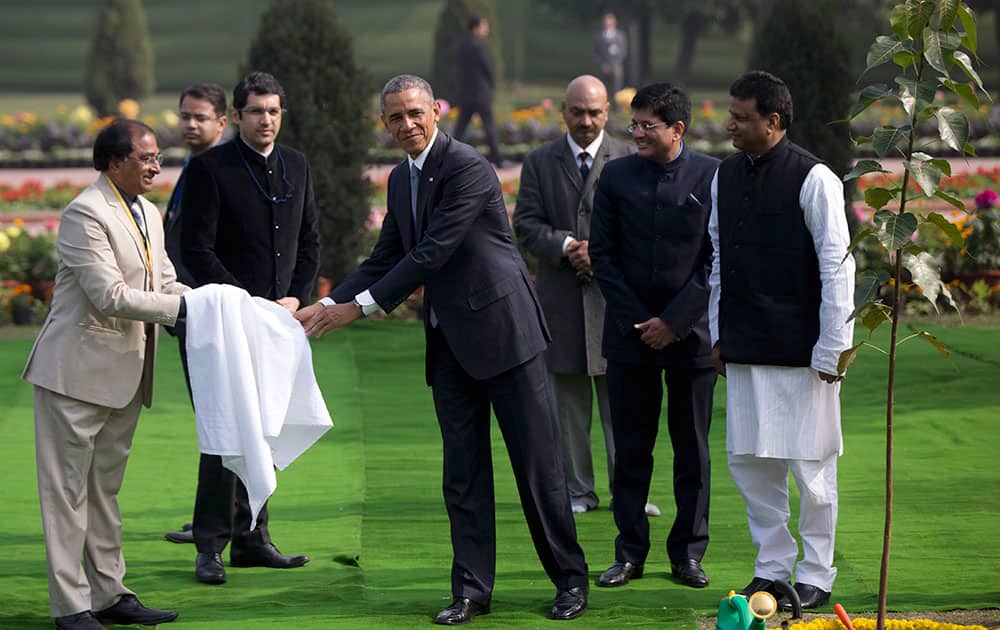 President Barack Obama wipes his hands with a towel after participating in a tree planting ceremony at the Raj Ghat Mahatma Gandhi Memorial in New Delhi, India.