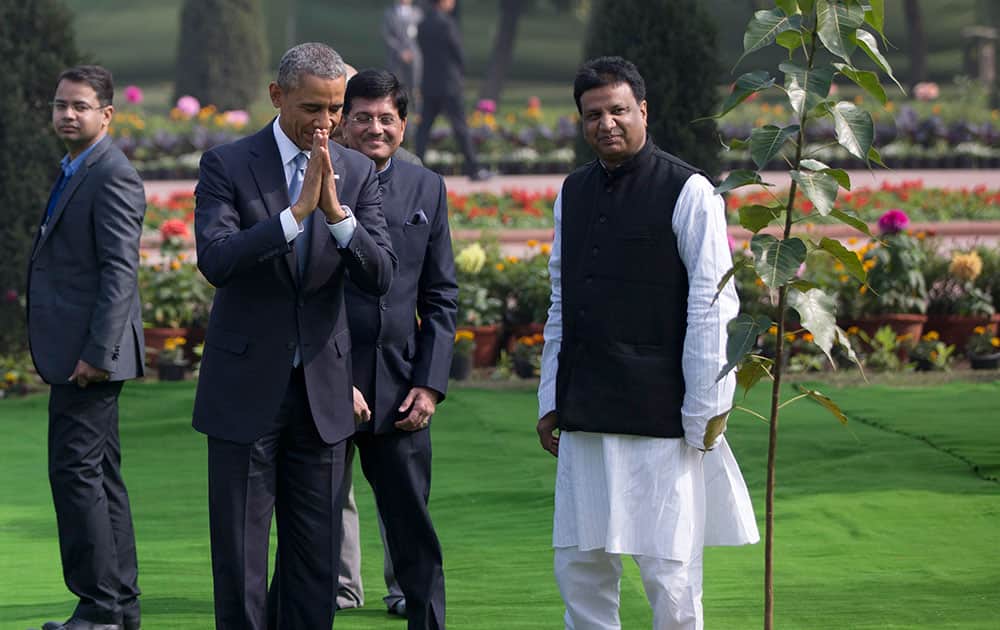 President Barack Obama clasps his hands as he bows after participating in a tree planting ceremony at the Raj Ghat Mahatma Gandhi Memorial in New Delhi, India.