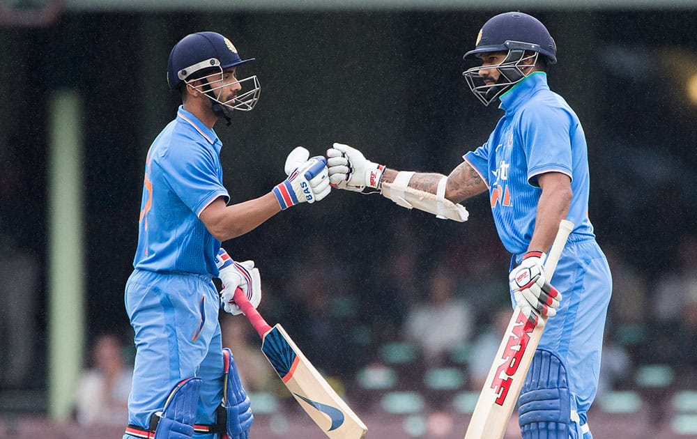 Ajinkya Rahane, left, is congratulated by his batting partner Indian Shikhar Dhawan after scoring a 4 during their one-day international cricket match in Sydney, Australia.