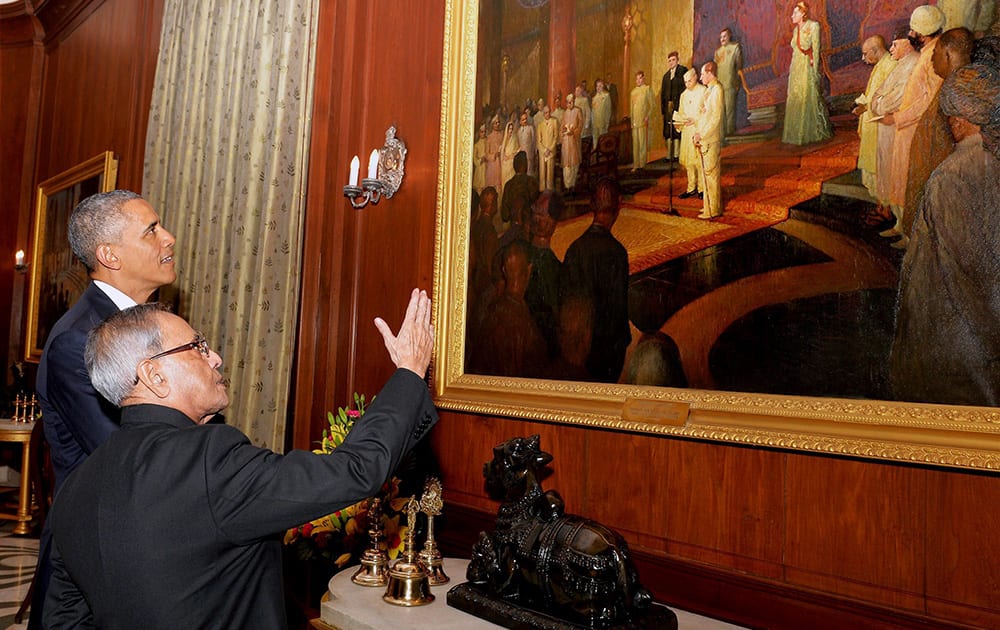 President Pranab Mukherjee showing a photograph to US President Barack Obama during a banquet hosted in the latters honour at the Rashtrapati Bhavan in New Delhi.