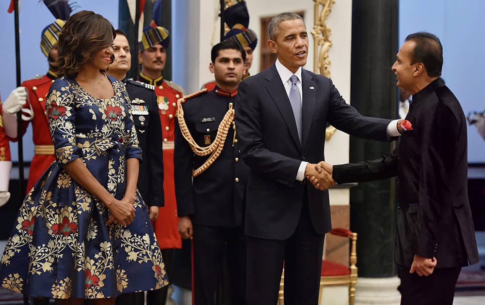 US First Lady Michelle Obama looks on as US President Barack Obama shakes hands with industrialist Anil Ambani during a banquet hosted at the Rashtrapati Bhavan in New Delhi.