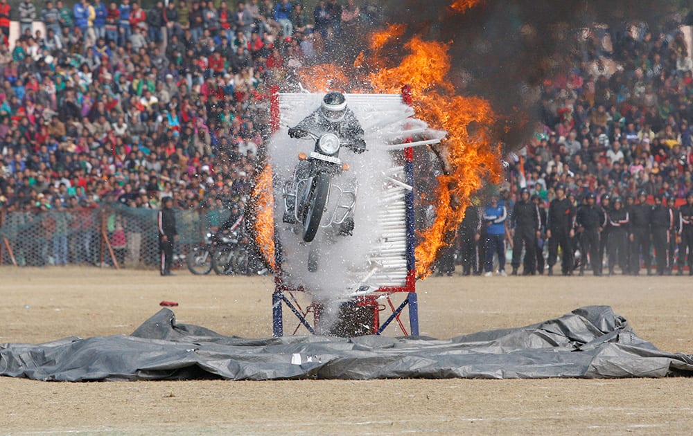 Jammu and Kashmir state policeman performs a motorcycle stunt during Republic Day parade in Jammu.