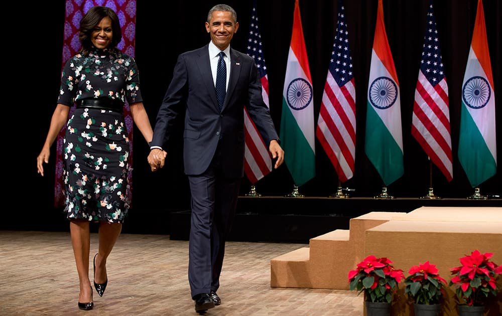 U.S. President Barack Obama walks from the stage with first lady Michelle Obama after speaking at the Siri Fort Auditorium in New Delhi.