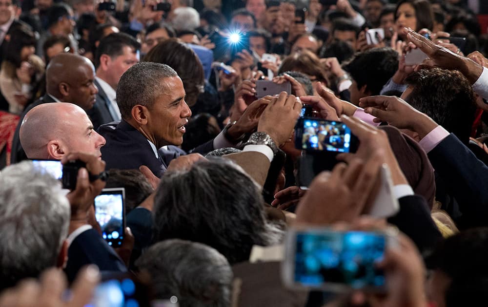 U.S. President Barack Obama greets people in the audience after speaking at the Siri Fort Auditorium in New Delhi.