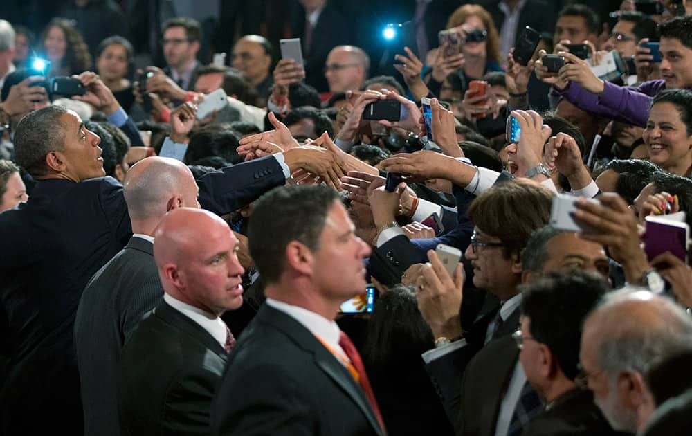 U.S. President Barack Obama greets people in the audience after speaking at the Siri Fort Auditorium in New Delhi.