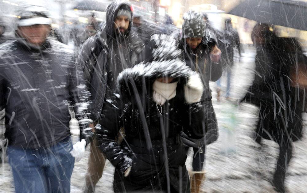 Pedestrians make their way through driving snow in midtown Manhattan in New York. More than 35 million people along the Philadelphia-to-Boston corridor rushed to get home and settle in Monday as a fearsome storm swirled in with the potential for hurricane-force winds and 1 to 3 feet of snow that could paralyze the Northeast for days. 