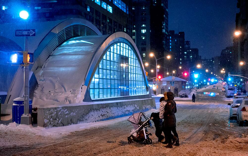 People cross a snow covered Broadway in the Upper West Side neighborhood of New York. People in the Northeast by the thousands are preparing for a snowstorm that could be one for the history books, with some 35 million people in its path in the Philadelphia-to-Boston corridor.