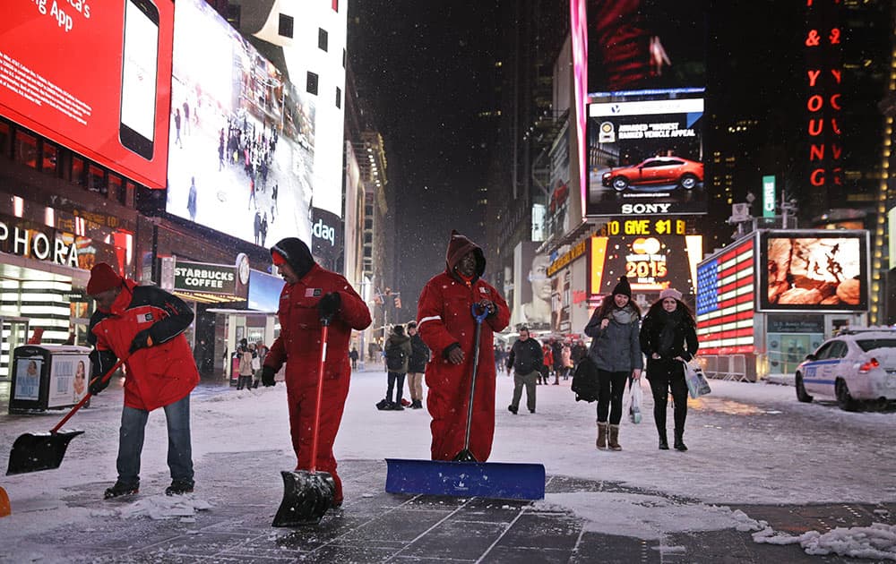 Men shovel a pedestrian walkway in New York's Times Square.